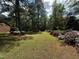 A large backyard features a grassy lawn, flowering azaleas, and mature trees offering ample space for outdoor activities at 184 Pine E St, Lillington, NC 27546