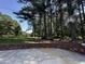 Brick wall encloses concrete backyard area with a basketball hoop and wooded surround at 184 Pine E St, Lillington, NC 27546
