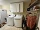 Bright laundry room with washer, dryer, storage cabinets and wire shelving at 184 Pine E St, Lillington, NC 27546
