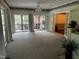 Bright living room featuring neutral carpet, ceiling fan and sliding glass doors to the outdoor balcony at 184 Pine E St, Lillington, NC 27546