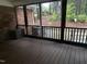 View of covered porch with wooded backyard and exterior AC unit and dark brown wood floorboards at 184 Pine E St, Lillington, NC 27546