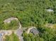 Expansive aerial view of a luxury home nestled in a lush, green, wooded lot at 222 Kenwood Ln, Pittsboro, NC 27312