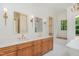 A bathroom with double vanity, decorative mirrors, lighting, and a soaking tub at 222 Kenwood Ln, Pittsboro, NC 27312