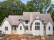 An exterior of a white two-story house with brick and gray trim and a stone chimney at 222 Kenwood Ln, Pittsboro, NC 27312