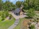 Outdoor living space with fireplace, covered entertaining area, and natural stone pathway at 222 Kenwood Ln, Pittsboro, NC 27312