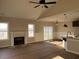 Open-concept living room with fireplace, large windows, and sliding glass doors to the patio at 941 Olive Branch Dr, Smithfield, NC 27577