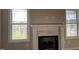 Living room featuring a fireplace with decorative mantle and natural light from two windows at 941 Olive Branch Dr, Smithfield, NC 27577