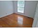 Empty bedroom with hardwood floors, white walls, and a large window with blinds at 1917 New Hill Olive Chapel Rd, New Hill, NC 27562