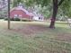 Exterior shot of the rear of the home and yard featuring large mature trees at 1917 New Hill Olive Chapel Rd, New Hill, NC 27562