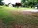 Exterior view of a well-maintained yard with green grass, a basketball hoop, and a detached garage at 1917 New Hill Olive Chapel Rd, New Hill, NC 27562
