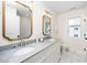 Stylish bathroom with a dual sink vanity, granite countertops, framed mirrors, and marble-style flooring at 195 N Smith St, Clayton, NC 27520