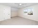 Well-lit bedroom with neutral carpet, a white ceiling fan, and a window that frames the outside view at 195 N Smith St, Clayton, NC 27520