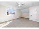 Bright bedroom with neutral carpet, a ceiling fan, and a window for natural light, and a white door at 195 N Smith St, Clayton, NC 27520
