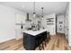 Modern kitchen boasts white cabinetry, stainless steel appliances, and a center island with bar seating at 195 N Smith St, Clayton, NC 27520