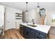 Modern kitchen with a stainless steel sink, pendant lights, open shelving, and a staircase nearby at 195 N Smith St, Clayton, NC 27520