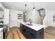 Modern kitchen with navy island, stainless steel appliances, and a staircase at 195 N Smith St, Clayton, NC 27520