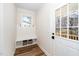 Welcoming mudroom with built-in bench, storage baskets, coat hooks, and a window by the entry door at 195 N Smith St, Clayton, NC 27520
