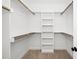 Organized walk-in closet featuring shelves and rods for ample storage with neutral carpet flooring at 195 N Smith St, Clayton, NC 27520
