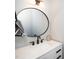 Modern bathroom with a sleek vanity, round mirror, and stylish fixtures at 199 N Smith St, Clayton, NC 27520