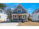 Gray two-story home with a welcoming front porch and an American flag at 199 N Smith St, Clayton, NC 27520