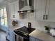 Modern kitchen with stainless steel range hood and white cabinets and countertops at 199 N Smith St, Clayton, NC 27520
