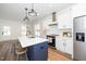 Bright kitchen with white cabinets, stainless steel appliances, and a blue island with a white countertop at 199 N Smith St, Clayton, NC 27520