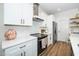 Modern kitchen with stainless steel range hood and white cabinets and countertops at 199 N Smith St, Clayton, NC 27520