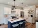 Bright kitchen features a large island with seating, pendant lighting, and stainless steel appliances at 199 N Smith St, Clayton, NC 27520