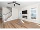 Bright living room with fireplace, flat screen TV, and hardwood floors, next to a staircase at 199 N Smith St, Clayton, NC 27520