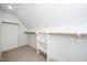 Bright, empty walk-in closet with white shelves and clothes bars, and carpet at 199 N Smith St, Clayton, NC 27520