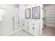 Elegant bathroom featuring double vanity, walk-in shower, and access to walk-in closet at 201 N Smith St, Clayton, NC 27520