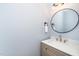 Well-lit powder room features a stylish vanity with a round mirror and modern fixtures at 201 N Smith St, Clayton, NC 27520