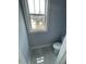 Cozy bathroom with gray tile flooring, toilet, and a window with natural light at 201 N Smith St, Clayton, NC 27520