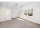 Bright bedroom features neutral carpeting, a ceiling fan, and a large window at 201 N Smith St, Clayton, NC 27520