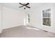 Light-filled bedroom with neutral carpet, two windows, and a modern ceiling fan at 201 N Smith St, Clayton, NC 27520