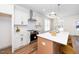 Bright kitchen features white cabinetry, quartz counters, tile backsplash, and center island at 201 N Smith St, Clayton, NC 27520