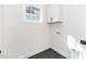 Bright laundry area with white cabinets, window, and connections for washer and dryer at 201 N Smith St, Clayton, NC 27520