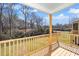 Covered porch with wooden railings offers serene views of the surrounding landscape at 201 N Smith St, Clayton, NC 27520