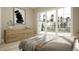 Bedroom with large windows, light wood floors, and a modern dresser with minimalistic artwork at 725 Catawba St, Raleigh, NC 27609