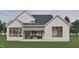 A modern farmhouse-style home with white siding, black roof, outdoor seating, and spacious covered patio at 725 Catawba St, Raleigh, NC 27609
