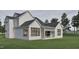 A modern farmhouse-style home with white siding, black roof, outdoor fireplace, and spacious covered patio at 725 Catawba St, Raleigh, NC 27609