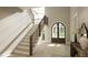 A grand foyer with a wooden staircase and an arched front door welcomes you into this home at 725 Catawba St, Raleigh, NC 27609