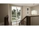 Bright staircase with a modern chandelier, large windows, and dark wood railings at 725 Catawba St, Raleigh, NC 27609