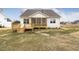 A backyard with a wooden deck, screened porch, and a view of the lawn and a neighbor's house at 73 Jumper St, Wendell, NC 27591