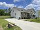 Lovely home showcasing a side-entry garage, stone accents, and a well-manicured lawn at 73 Jumper St, Wendell, NC 27591