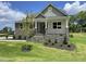 Inviting exterior showing stone accents, landscaped yard, and charming covered porch at 73 Jumper St, Wendell, NC 27591