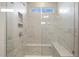 Modern bathroom shower featuring marble tile, built-in shelves, and a glass enclosure at 73 Jumper St, Wendell, NC 27591