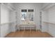 Bright, walk-in closet with wooden floors, bench seating, and window with views of the neighborhood at 30 Chestnut Oak Dr, Youngsville, NC 27596