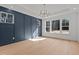 Bright dining room featuring a modern chandelier, blue accent wall, and large windows with a view at 30 Chestnut Oak Dr, Youngsville, NC 27596