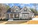 Beautiful two-story home with gray siding, black accents, and a landscaped front yard under a partly cloudy sky at 30 Chestnut Oak Dr, Youngsville, NC 27596
